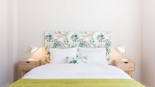 a bedroom with a large bed with two night stands at Praça 44 in Braga