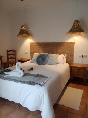 a bedroom with a white bed with a swan on it at El rincón del Vadillo in La Velilla
