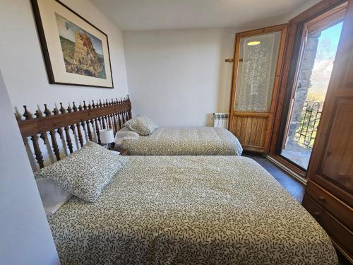 a bedroom with two beds and a window at Casa Martín in Guaso
