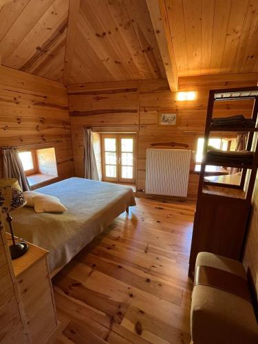 a bedroom with a bed in a wooden cabin at Chambre de charme in Berbezit