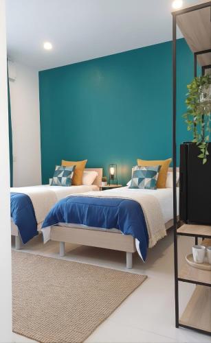 two beds in a room with a blue wall at Oris in Oristano