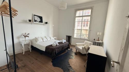 a bedroom with a bed and a chair and a window at Home lab studio in Córdoba