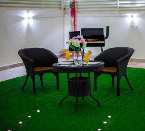 a table with a vase of flowers on it with chairs at Rest Night Serviced Apartments- AlHamra in Riyadh
