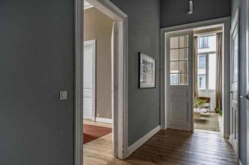 a hallway with white doors and wood floors at A Place Antwerp - Boutique Suites & Flats - Schuttershofstraat 1 in Antwerp
