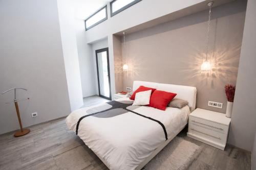 a bedroom with a large white bed with red pillows at Catalunya Casas Modern Marvel,15 min to Costa Brava beaches! in Sils