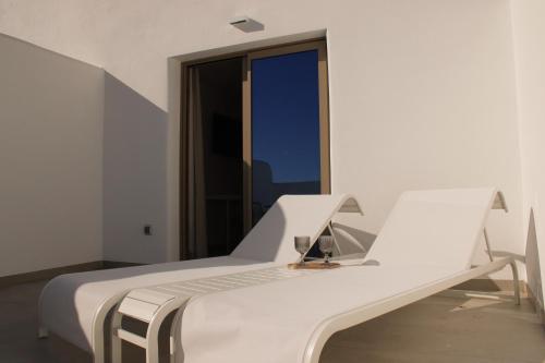 a white bed in a room with a window at HA Hotel TESORO MEDITERRANEO in Almuñécar