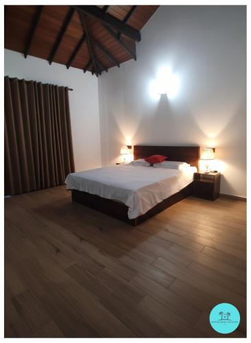 a bedroom with a bed with two lamps on it at Nuwan Home Vacation Villa in Wennappuwa