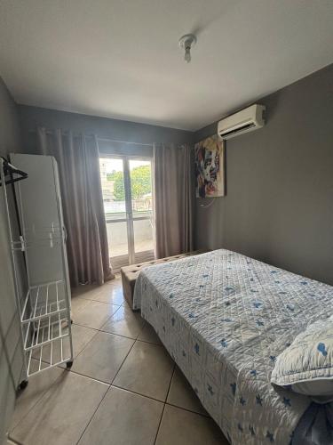 a bedroom with a bed and a ladder and a window at Casa em itapema fácil acesso e bem localizada in Itapema