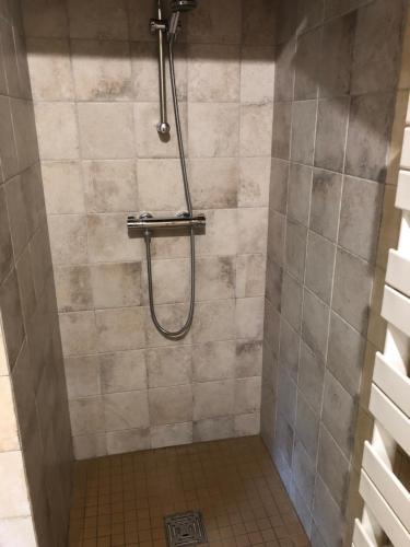 a shower with a hose in a bathroom at Chambres La Vallée in Salbris
