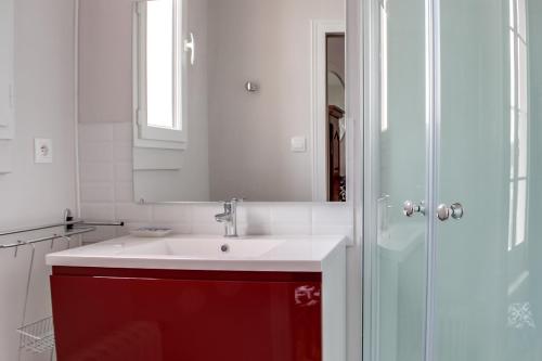 a bathroom with a red sink and a mirror at Maison Carteret à 10 mn Lac du Der plages port casino confort et calme jardin bbq in Montier-en-Der