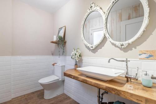 a bathroom with a sink and a toilet and a mirror at Ca'n Tosca Jávea in Jávea