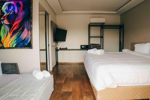 a bedroom with two beds and a painting on the wall at Roga Village in Atibaia