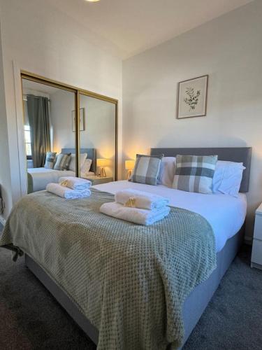 a bedroom with two beds and a large mirror at Central 1BR Apt with Parking in Auchterarder