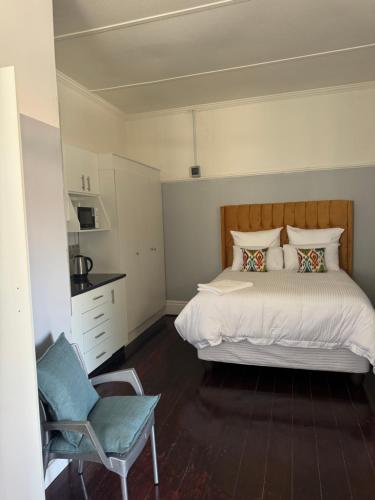 a bedroom with a large bed and a chair at Legacy lodge in Goodwood