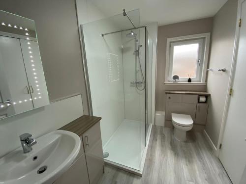 a bathroom with a shower and a sink and a toilet at Kirkwall town centre apartment 3 in Kirkwall