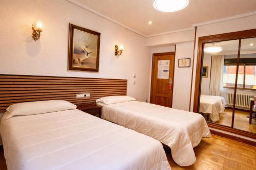 a hotel room with two beds and a window at Hotel Castellano I in Salamanca