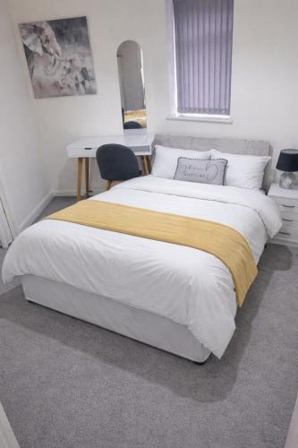 a bedroom with a large bed with a desk at Golden Stay in Wyken