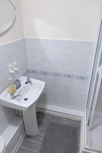 a white bathroom with a sink and a shower at Golden Stay in Wyken