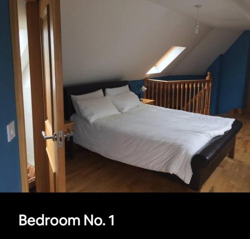a bedroom with a bed with a white comforter at Curraghchase Cottage in Limerick