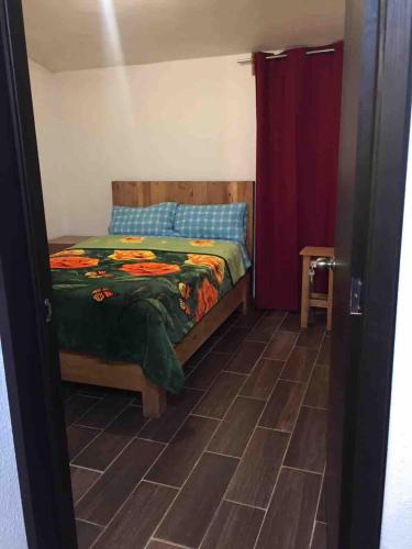a bedroom with a bed and a tiled floor at Casa Sustentable Monarca Angangueo in Mineral de Angangueo
