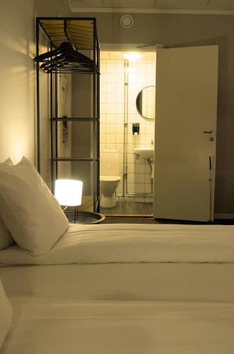 a bedroom with a bed and a bathroom with a toilet at Grad Hotel and Hostel in Stockholm