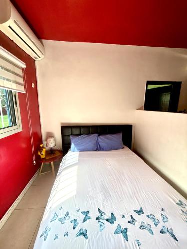 a bed in a room with a red wall at Residence Mamie Léo in Abidjan