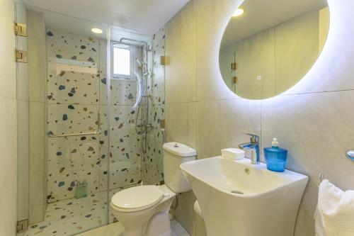 a bathroom with a toilet and a sink and a shower at City Rental London theme in Batroûn