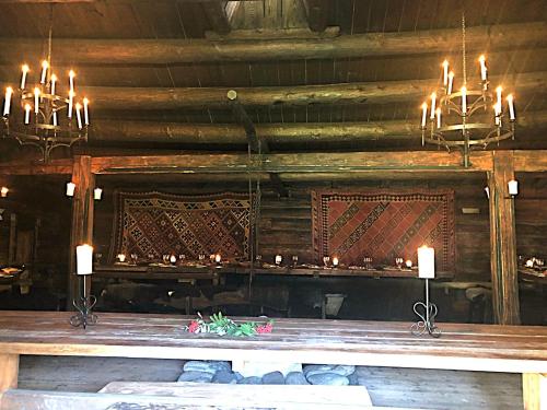 a dining room with chandeliers and a table with candles at Jørundgard Vikingcamp in Sel
