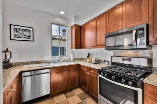 a kitchen with wooden cabinets and a stove top oven at Poolside Greens 3BR Legacy Villa in La Quinta