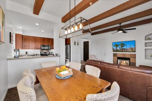 a kitchen and dining room with a wooden table and chairs at Poolside Greens 3BR Legacy Villa in La Quinta