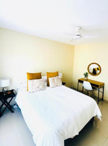 a bedroom with a large white bed and a desk at 12th on The Bay Apartment in Richards Bay