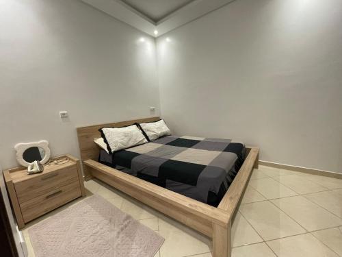 a small bedroom with a bed and a night stand at Appartement Moderne à Temara in Temara