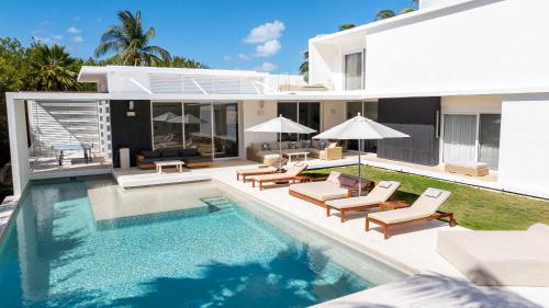 a villa with a swimming pool and a house at Villa Marazul 5BR Beach & Golf Access in Cancún