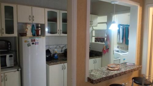 a kitchen with white cabinets and a white refrigerator at AP perto do HSVP com estacionamento in Passo Fundo