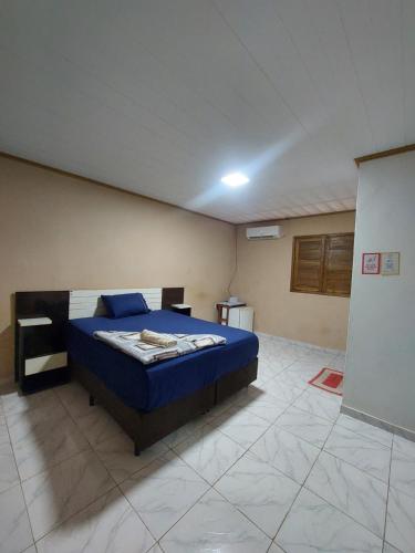 a bedroom with a blue bed in a room at Qroom Janaina in Cruzeiro do Sul