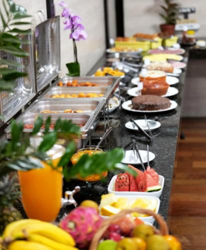 a buffet line with many plates of food and fruit at Hotel Pedra Moura in Vacaria