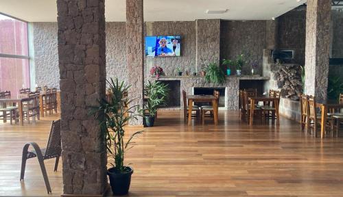 a restaurant with a fireplace and tables and chairs at Hotel Pedra Moura in Vacaria