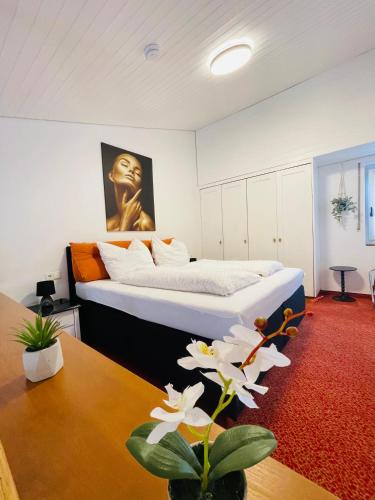 a bedroom with a king sized bed and a table at Das CLASSIQUE Galerieappartement 50qm - Elegant und geräumig wohnen - Espressomaschine, Airfryer, Balkon, Vierbeinerfreundlich, Parkgarage -AppHaus Poseidon in Bad Griesbach