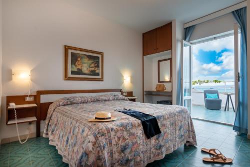 a hotel room with a bed with a hat on it at Hotel Vittoria in Porto Santo Stefano