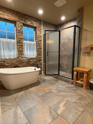 a bathroom with a tub and a glass shower at Yosemite's Inn the Woods in Ahwahnee