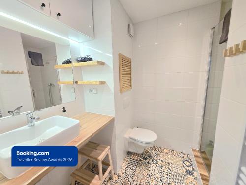 a bathroom with a sink and a toilet and a mirror at Apartman Point in Štrba