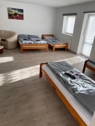 a room with two beds and a couch at Domek Ranczo in Mochnaczka Wyżna