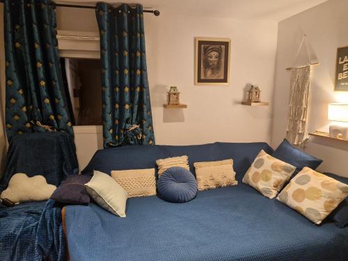 a blue couch with pillows in a living room at Harmonie in Blésignac