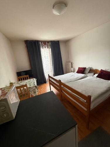 a bedroom with two beds and a table in it at Résidence « Les Crêtes » in Torgon