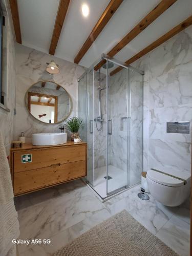 a bathroom with a shower and a toilet and a sink at Meco Beach House in Sesimbra