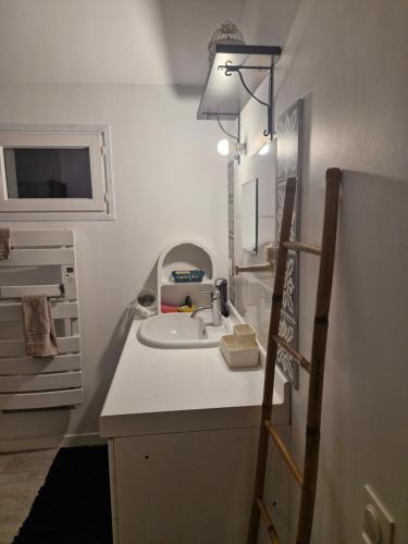 a white bathroom with a sink and a mirror at Harmonie in Blésignac