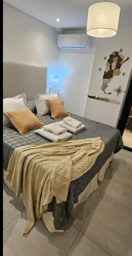 a bed in a room with towels on it at Alcazar Suites Premium in Salta