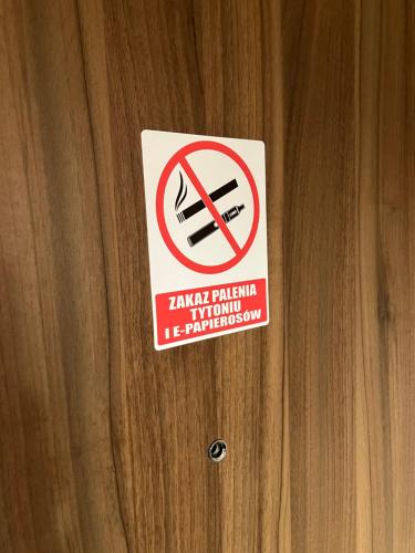 a sign is posted on a wooden door at Apartament Kołobrzeska 2 in Piła