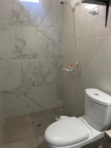 ein Badezimmer mit weißer Toilette und Dusche in der Unterkunft Herrera in Caucete