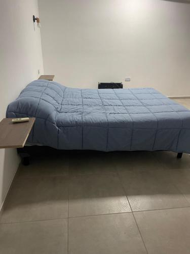 ein Bett mit einer blauen Bettdecke in einem Zimmer in der Unterkunft Herrera in Caucete